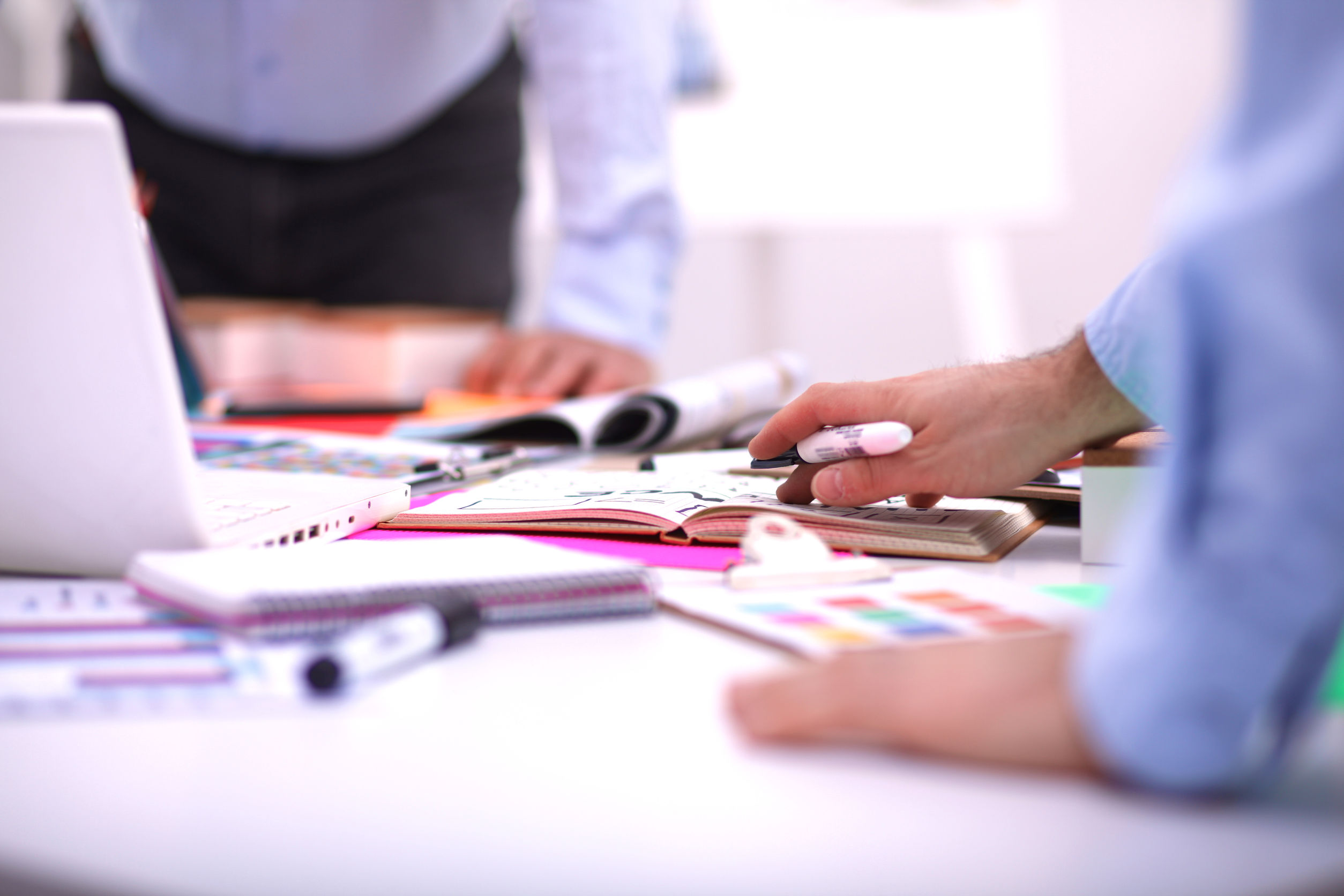 Close-up of three young creative designers working on project together. Team work.